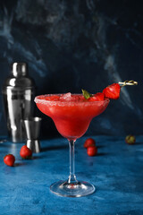 Glass of tasty strawberry margarita on color background
