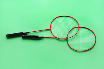 Badminton rackets on color background
