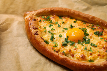 Tasty Ajarian khachapuri on parchment, closeup