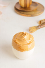 Glass of tasty dalgona hojicha latte on light background