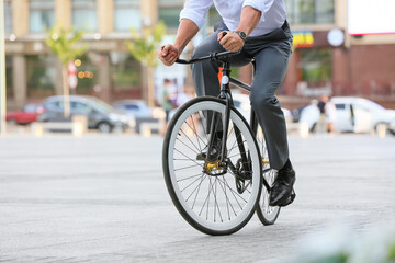 Fototapeta premium Businessman going to work by bicycle on city street