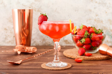Glass of tasty cosmopolitan cocktail on wooden background
