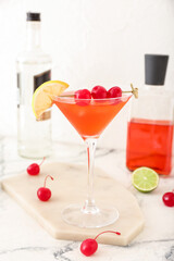 Glass of tasty cosmopolitan cocktail on light background