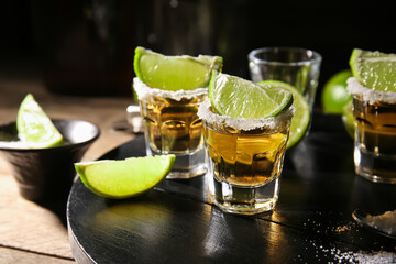 Shots of tasty tequila with lime on table