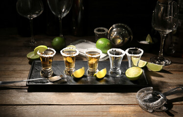 Shots of tasty tequila with lime on table in bar