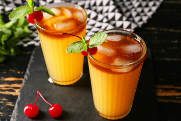 Glasses of tasty mai tai cocktail on dark wooden background