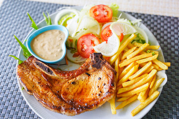porkchop steak with french fries and salad