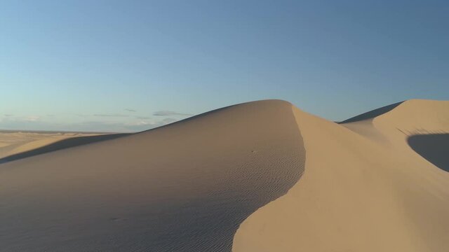 Aerial drone flight over sand dunes in the desert