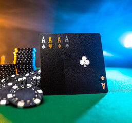 Casino. Gambling house. Poker cards, four aces, chips on a green poker table. Interesting lighting. Gambling, casino, poker club, risk, win, blackjack, gambling business. Close-up.