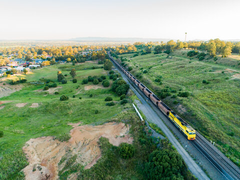 Coal train passing by on railroad at edge of Singleton, Hunter Valley