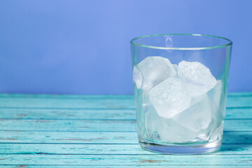 ice cubes in glass on blue background