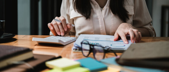 Close up a woman working about financial with calculator at his office to calculate expenses, Accounting concept.