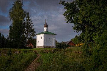 Fototapeta na wymiar View of the Chapel of the Korsunskaya Icon of the Mother of God on a sunny summer evening with clouds, Izborsk, Pskov region, Russia