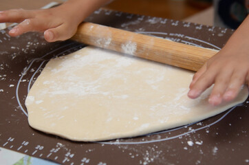 生地を伸ばし棒を使って両手で伸ばす