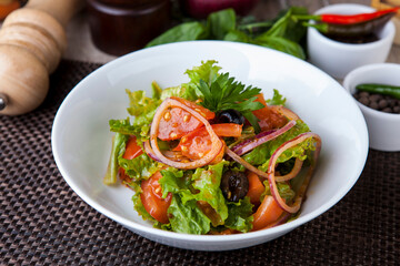 salad with greens tomatoes olives onions in a sweet sauce
