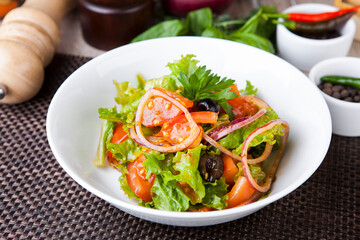 salad with greens tomatoes olives onions in a sweet sauce
