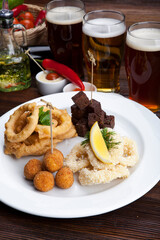plate with beer snacks, fried croutons, squid, onions and sauces