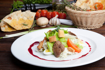 salad with pieces of pork, herbs, raspberry sauce and egg
