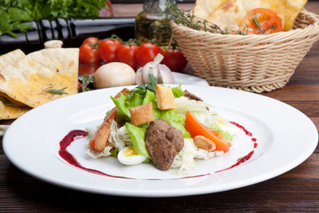 salad with pieces of pork, herbs, raspberry sauce and egg
