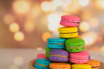 Delicious macaroons, a famous multicoloured French dessert in a stack. Selective focus. Blurred background