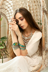Fototapeta premium Fashion portrait stylish brunette woman in boho style, a girl in a stylish bohemian chic interior