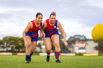 two female footballers approaching with eyes on the ball