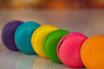 Delicious macaroons, a famous multicoloured French dessert in a row. Selective focus. Blurred background