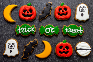 sweets gingerbread halloween pumpkin ghost zombie candy cane lettering trick or treat on a dark stone background
