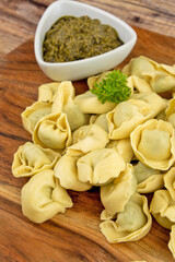 tas de tortellini cru sur une planche à découper