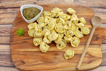 tas de tortellini cru sur une planche à découper
