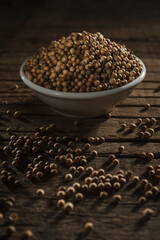 Coriander seeds against wooden background