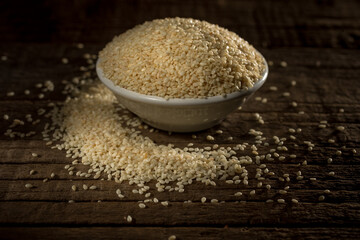 Organic natural sesame seeds against wooden background