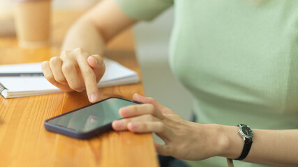 Close up, young woman using smartphone, touching mobile screen, surfing internet