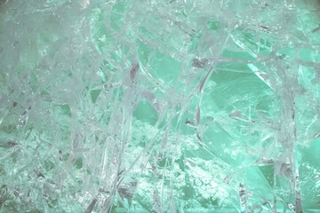 Shattered ice. Background image of a Broken frozen water, crystals. Glare of glass chips, traces of bullets on a transparent surface