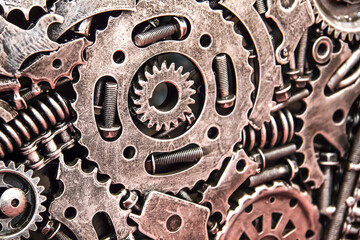 The texture of metal gears, bolts and screws, springs and metal parts on the wing of the car. Futuristic ancient vintage wall with mechanisms in the steampunk style. Background