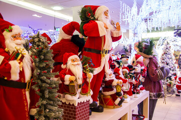 Christmas decoration shop: selling Christmas Santa Clauses, Christmas trees, gifts. Row of Santa...