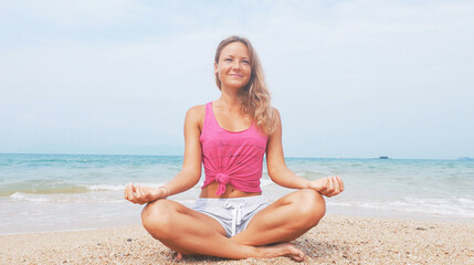 Fototapeta na wymiar Woman doing meditation near the ocean beach. Yoga silhouette.