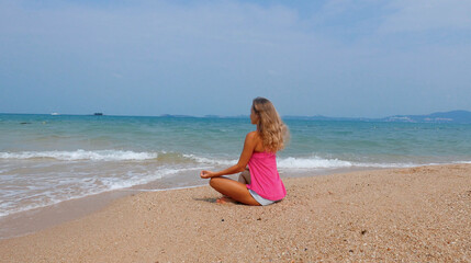 Fototapeta na wymiar Woman doing meditation near the ocean beach. Yoga silhouette.