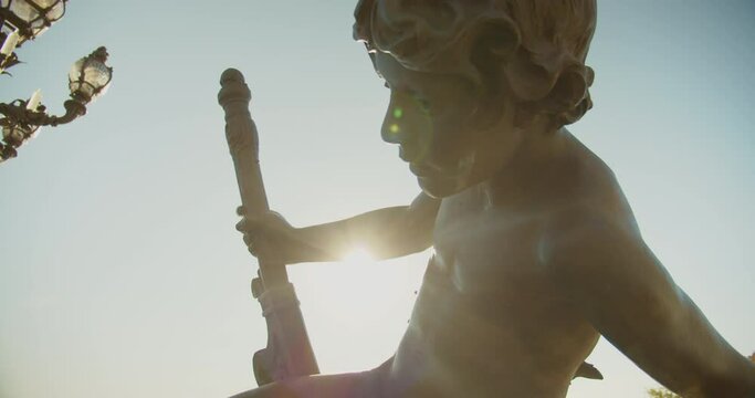 Sculpture Of A Boy At Pont Alexandre III Arch Bridge Backlit Sunlight In Paris, France. - Handheld
