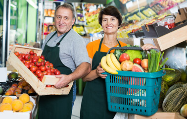 Man and woman sellers are demonstraiting basket with variety goods in the store