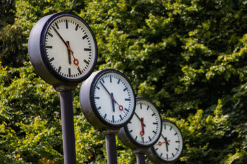 Classic black and white analog clocks with synchronized time show teamwork and synced project management with time management and deadlines in international teams running out of time ticking clocks
