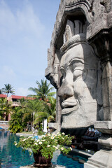 Obraz premium the head of a Thai god on the background of a pool and palm trees
