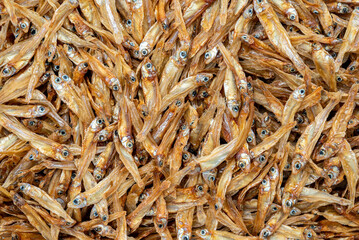 Dried anchovies fish on white background, macro image, fill frame with brown dried anchovies.