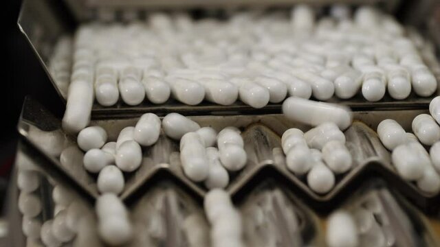 Pharmaceutical production. Medical capsules are moving in a packaging machine.