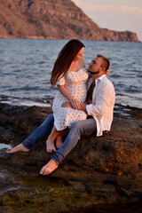 A young couple in love on the beach waiting for a child 