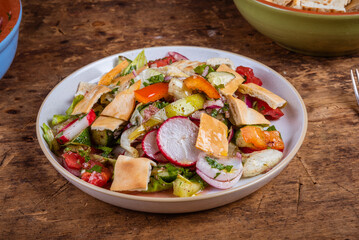 Fattoush vegan salad with tomatoes, onions, radishes, peppers, lettuce and pita on a plate - Lebanese cuisine
