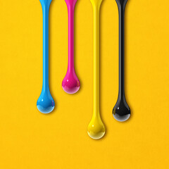 cmyk ink drops on yellow paper square background