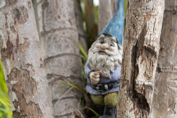 Shot of a gnome out of focus behind some logs in the garden
