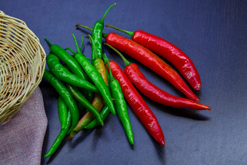 fresh organic red and green chili peppers on black background