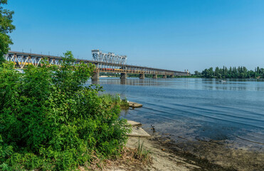 Fototapeta na wymiar Old metal bridge across the Dnieper River in Eastern Europe, Ukraine
